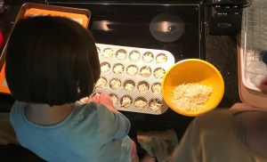 My daughter and I making these cheesy potato bites. Pictured is a bowl with the mix, plus a mini-muffin tin filled.